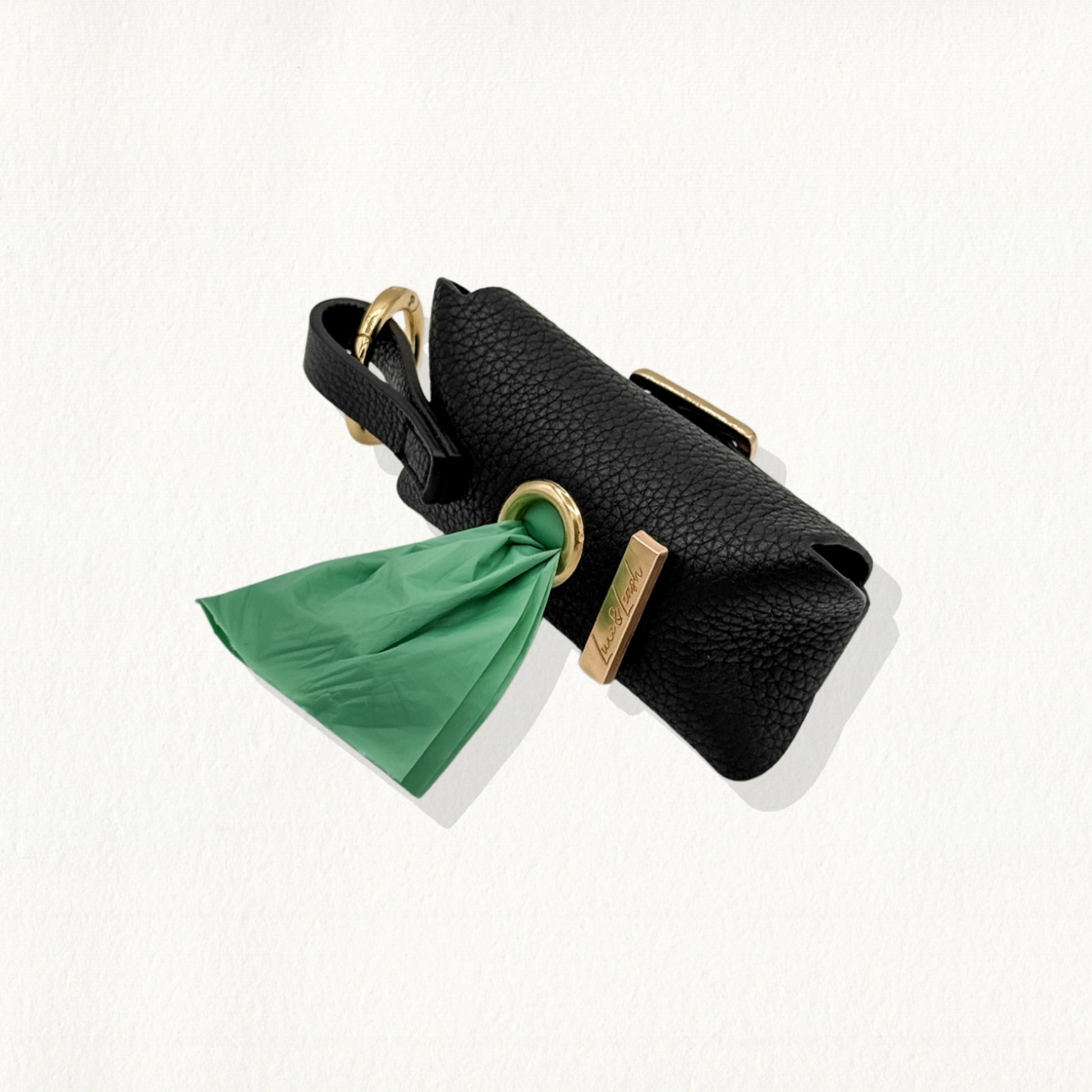 Noir leather waste bag dispenser with gold hardware and a "Luxe & Leash" metal bar.