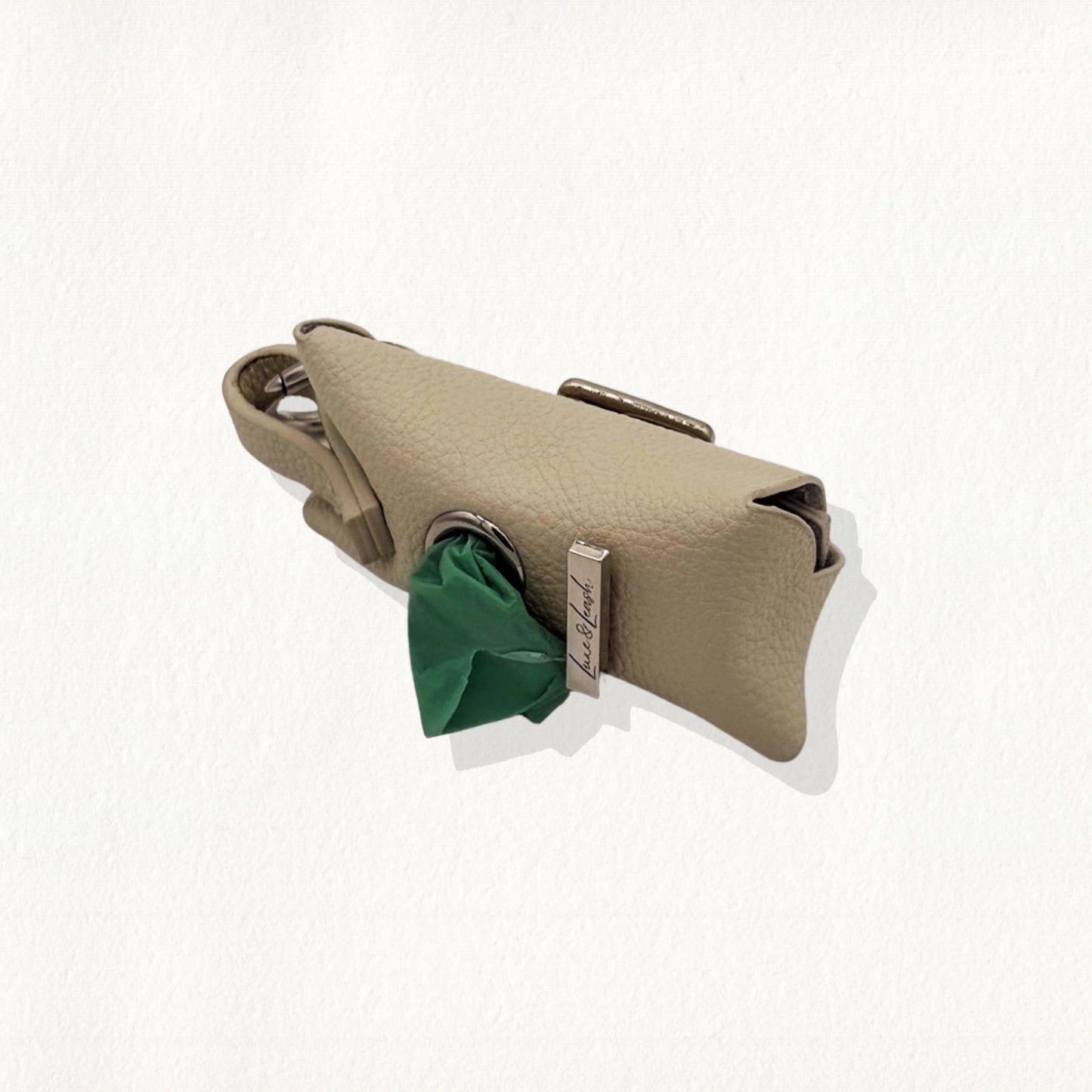 Sandstone leather waste bag dispenser with gold hardware and a "Luxe & Leash" metal bar.